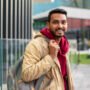 side-view-smiley-man-holding-backpack